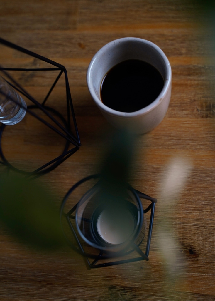 Schwarzer Kaffee auf Holztisch mit Deko